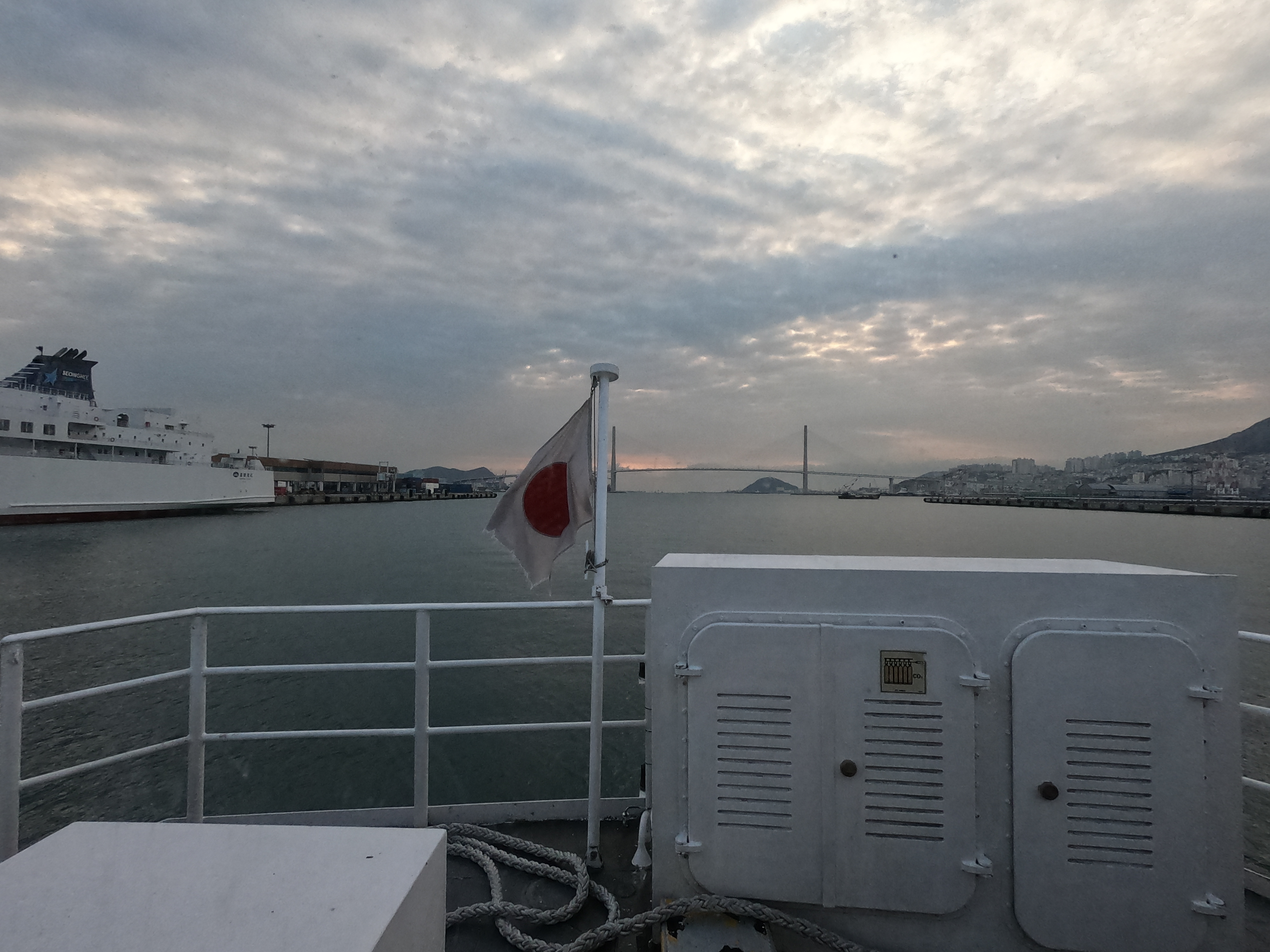 bandera japonesa con el puente de Busán de fondo